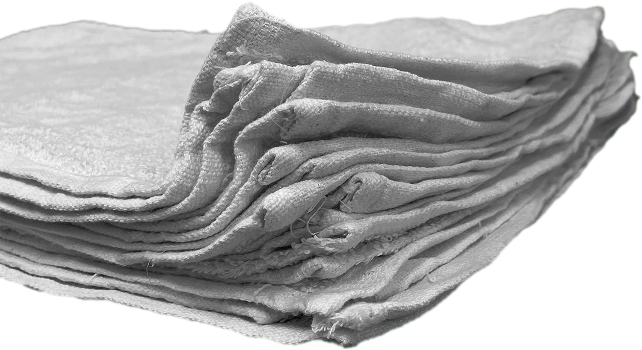 Closeup view from the corner of a stack of rags, without packaging, laid flat, and stacked neatly. Can clearly see the hemmed edges of the rags.